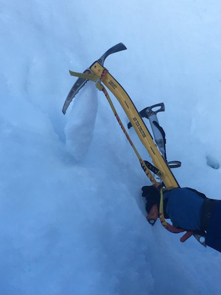 Ice tool placement on alpine mountaineering skills course